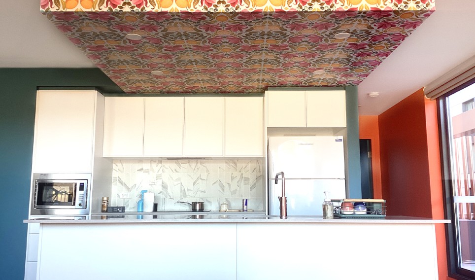 Modern kitchen interior featuring vibrant floral ceiling design, white cabinetry, and contemporary appliances, showcasing a stylish residential repaint by C&C Painting Group in Queanbeyan.