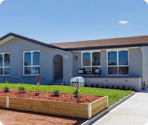 Modern residential home in Canberra with freshly painted exterior, landscaped front yard featuring plants and mulch, and a visible house number sign.