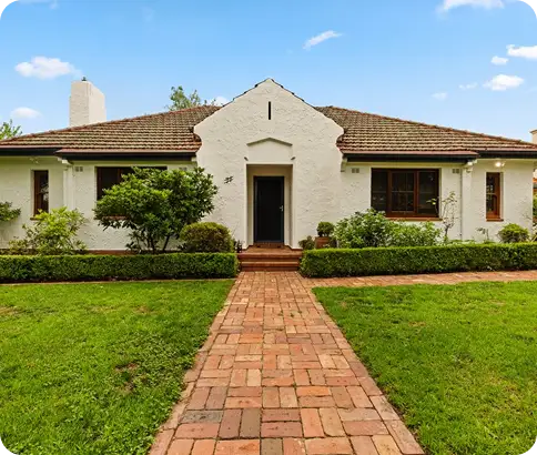 Residential home exterior with well-maintained garden and brick pathway, showcasing professional repainting by C&C Painting Group in Canberra.