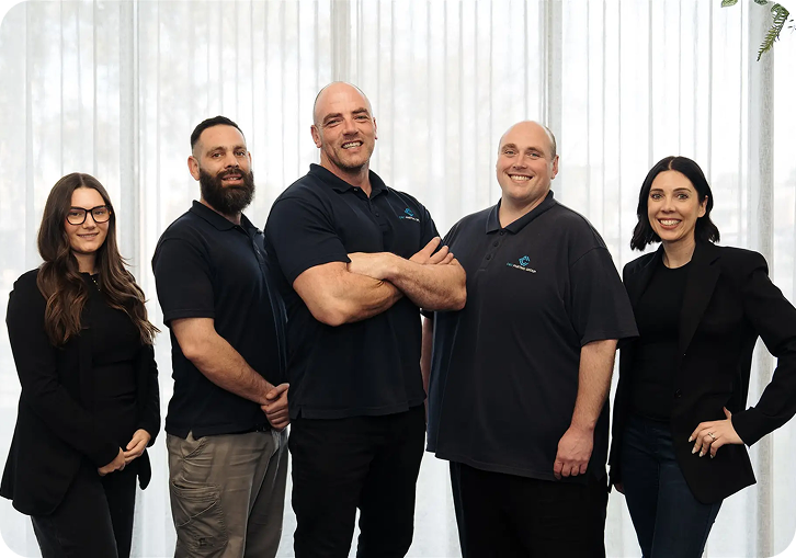 Team of professionals from C&C Painting Group, showcasing skilled painters and staff committed to quality workmanship and customer satisfaction, standing in a well-lit interior setting.