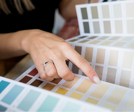 Hand pointing at colour swatches in a paint selection, illustrating choices for home painting projects with C&C Painting Group in Canberra.