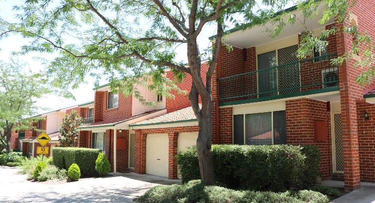 Strata residential buildings with brick facades and landscaped gardens, showcasing quality maintenance and a well-managed environment suitable for strata and body corporate properties in Canberra.