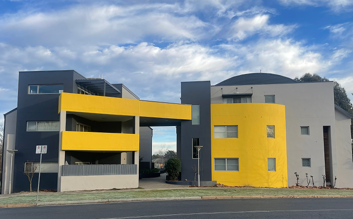 Strata residential building with modern design featuring grey and yellow exterior, showcasing C&C Painting Group's quality painting services for strata properties in Canberra.