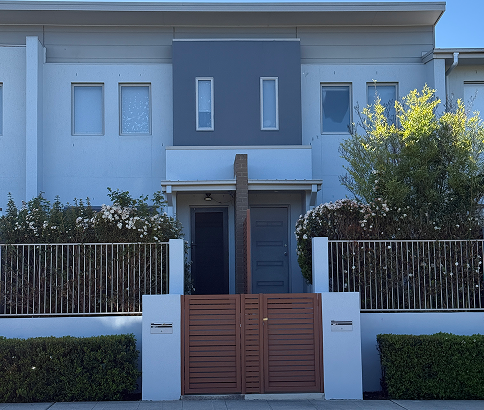 Modern strata property entrance with a stylish wooden gate, manicured hedges, and a clean, professional façade, reflecting C&C Painting Group's commitment to maintaining high-quality finishes in residential spaces.