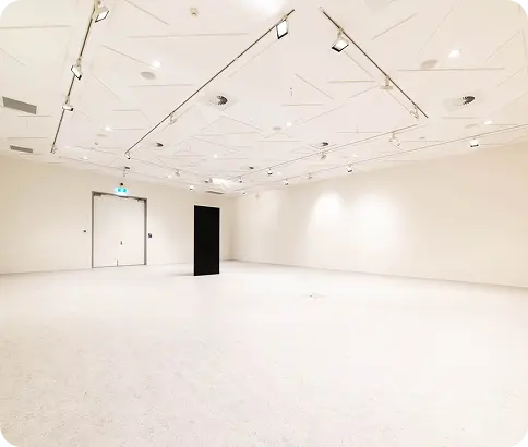 Modern, empty interior space with white walls, ceiling lights, and a black rectangular structure, suitable for commercial painting projects by C&C Painting Group.