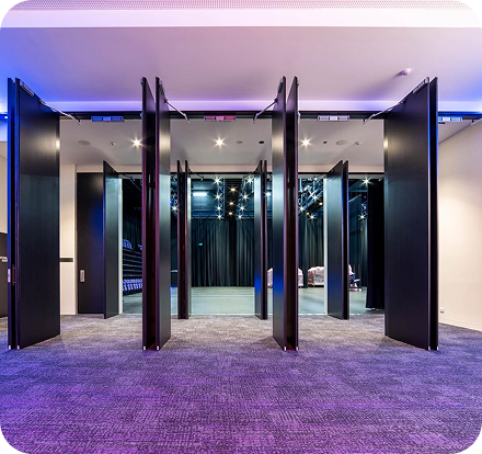 Modern interior space with retractable partition doors, showcasing a flexible layout for events and gatherings, emphasising C&C Painting Group's expertise in commercial and government painting services.