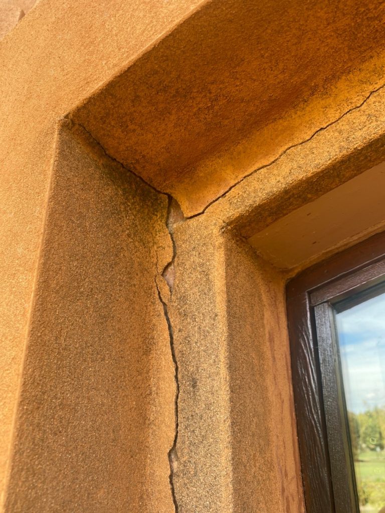 Cracked exterior wall near window, highlighting the need for repair and restoration in residential projects by C&C Painting Group.