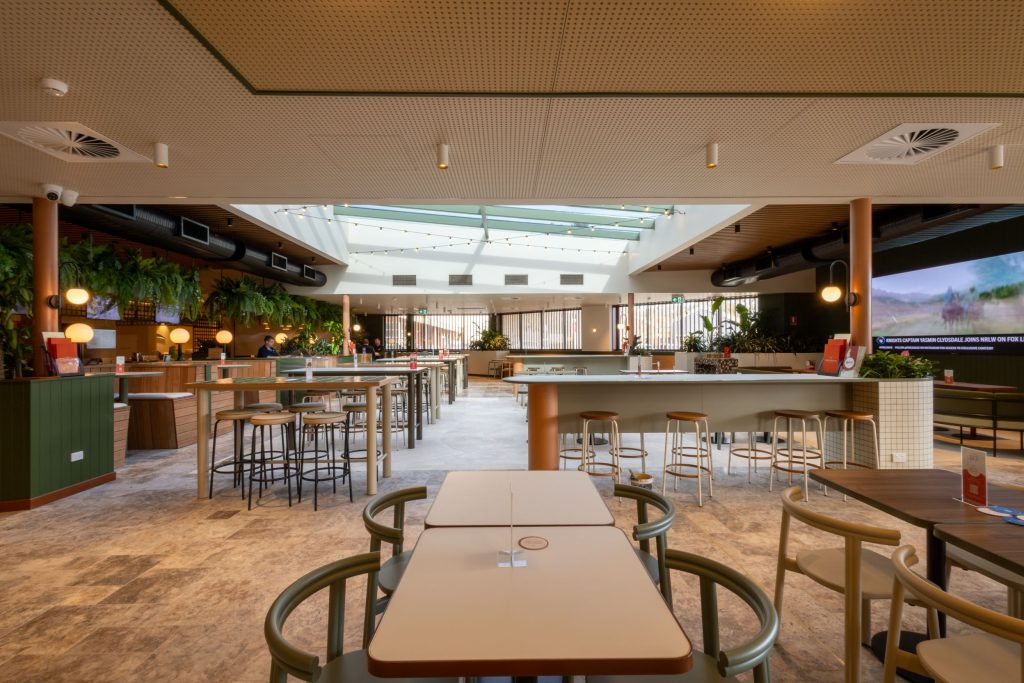 Interior of Canberra Southern Cross Club featuring modern seating arrangements, bar area, and lush greenery, showcasing commercial painting by C&C Painting Group.