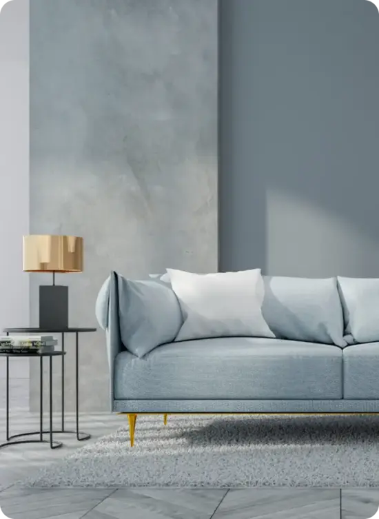 Modern light blue sofa with white pillows, stylish gold lamp on a black side table, and textured gray wall, illustrating a fresh interior design concept for high-end residential spaces.